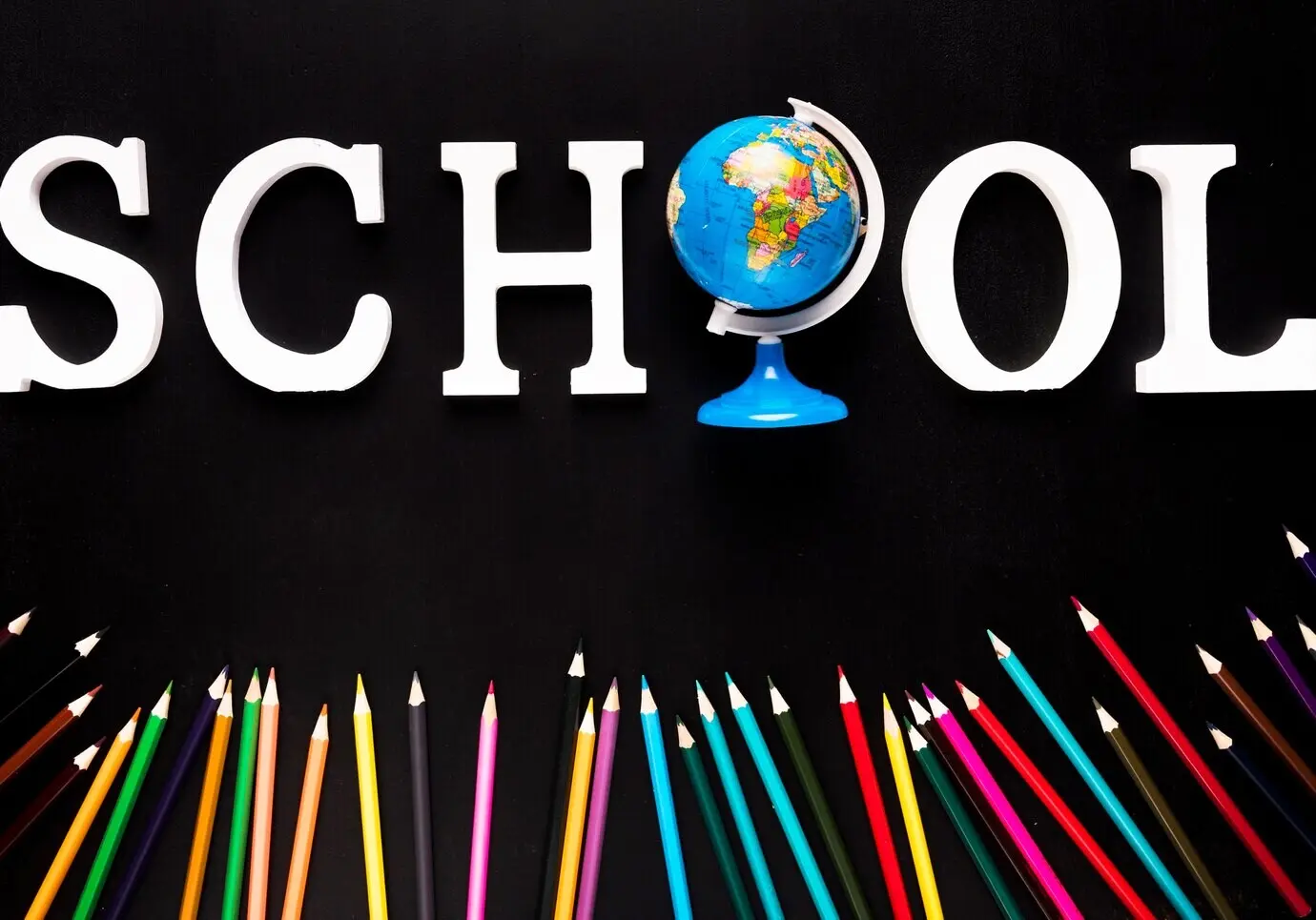 Logo der Schule und bunte Bleistifte